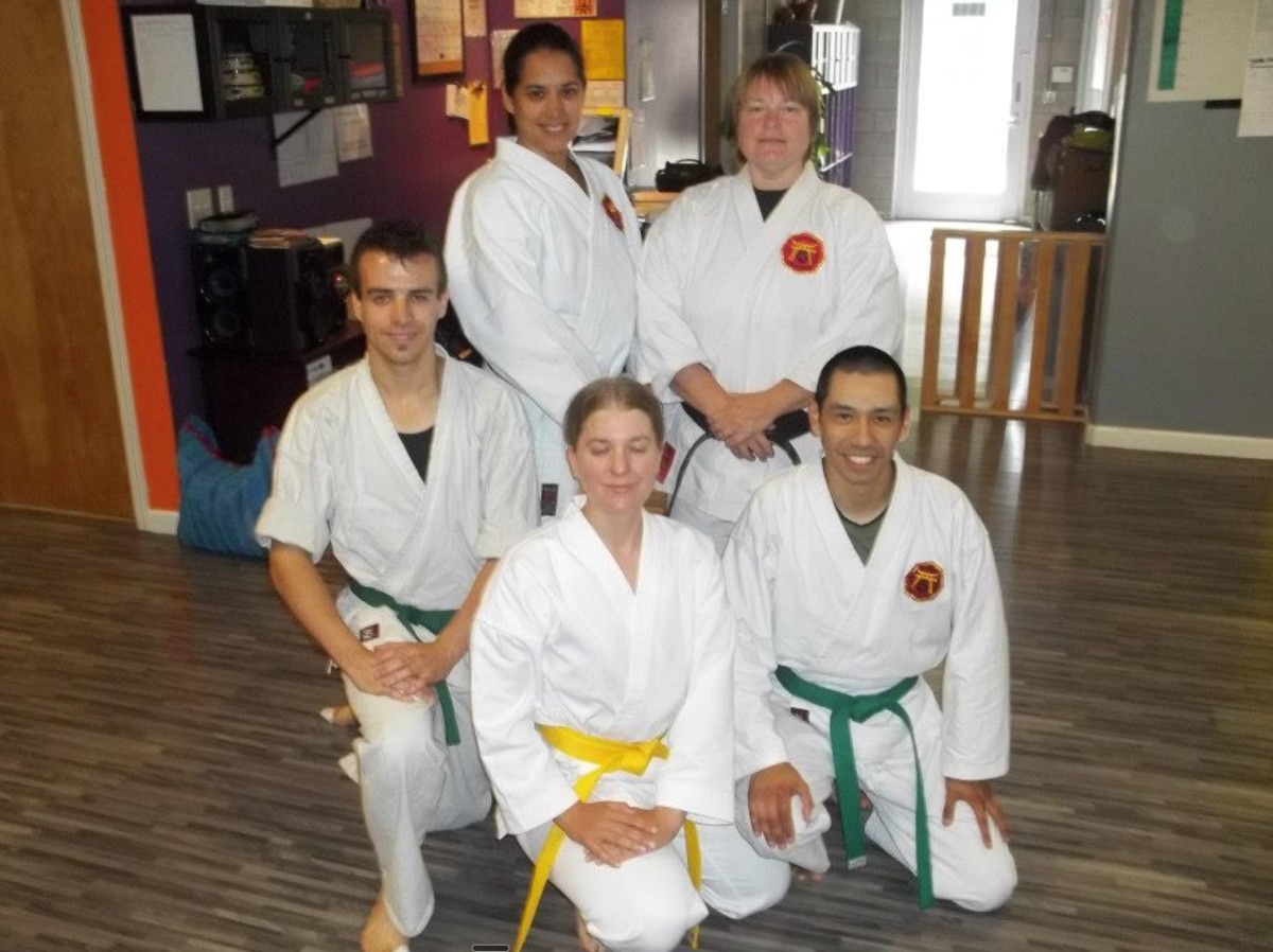 A small group kneeling in the dojo